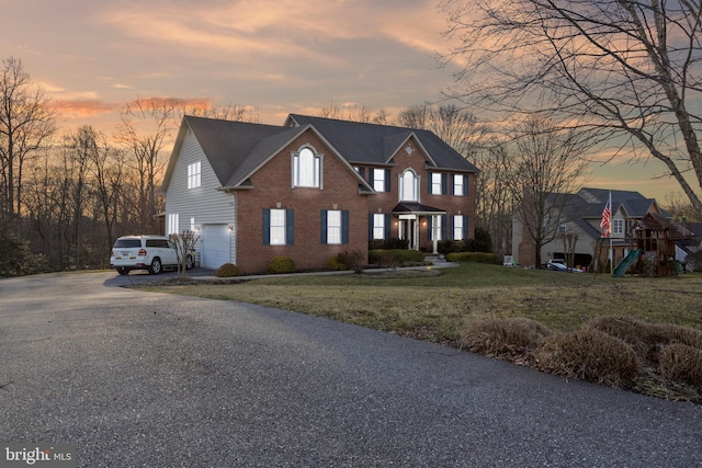 colonial-style house with a yard and a garage