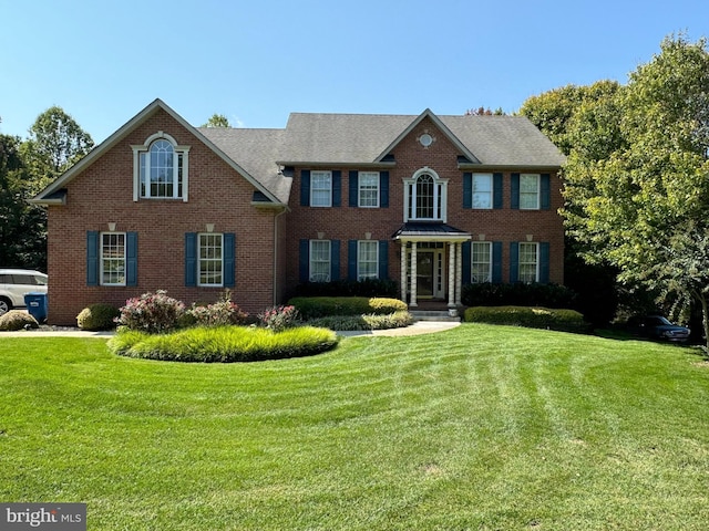 colonial home featuring a front lawn