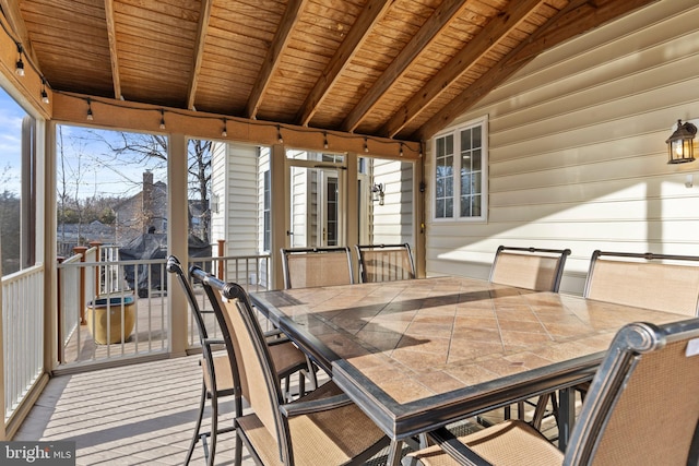 sunroom / solarium with vaulted ceiling with beams, wood ceiling, and track lighting