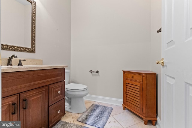 bathroom featuring vanity, tile patterned floors, and toilet