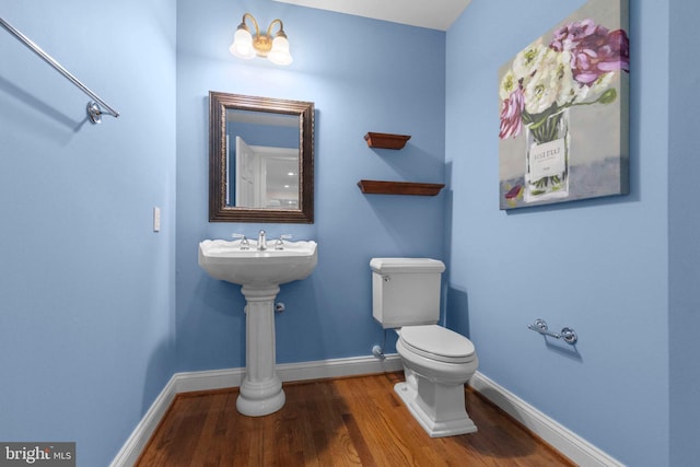 bathroom featuring wood-type flooring and toilet