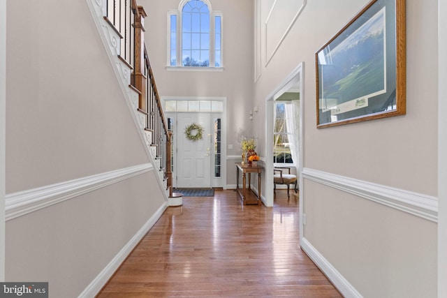 entrance foyer featuring a towering ceiling and hardwood / wood-style floors