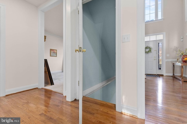 hall featuring hardwood / wood-style flooring and a towering ceiling