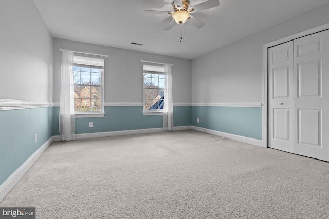 unfurnished bedroom featuring light carpet, a closet, and ceiling fan