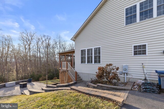 view of home's exterior with a patio area and an outdoor fire pit