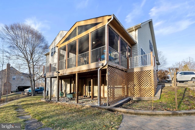 view of front of home featuring a sunroom and a front lawn