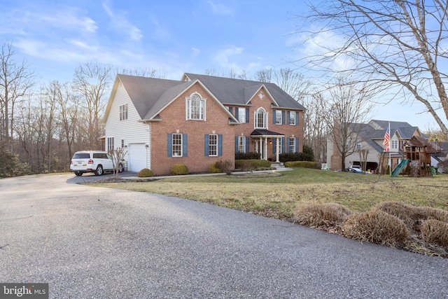 view of front of house with a garage, a front yard, and a playground