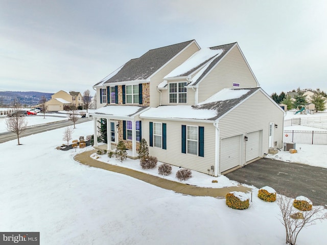 view of front of property featuring a garage and central air condition unit