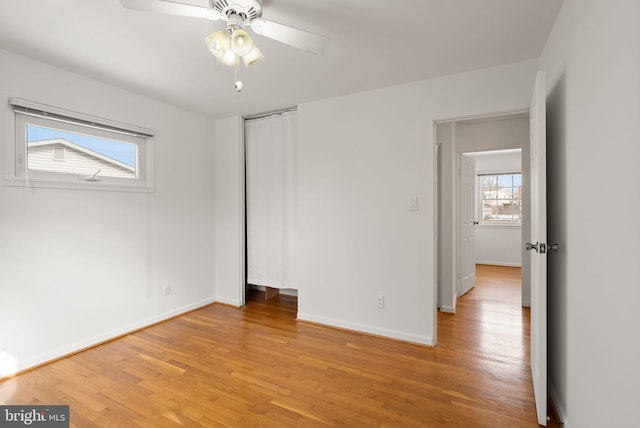 unfurnished bedroom featuring ceiling fan, light hardwood / wood-style floors, and multiple windows