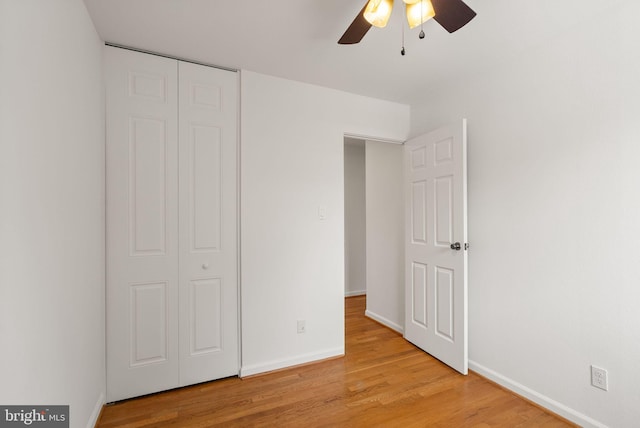 unfurnished bedroom with a closet, ceiling fan, and light wood-type flooring