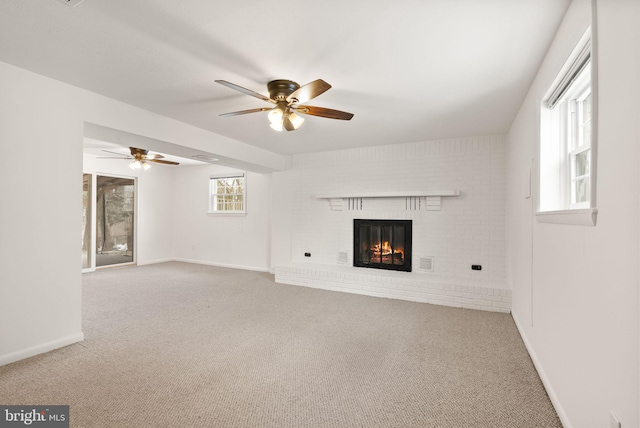 unfurnished living room with a brick fireplace, ceiling fan, and carpet