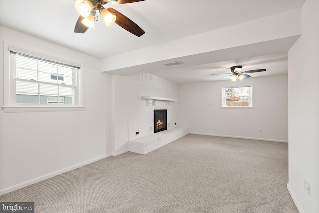 unfurnished living room with ceiling fan, a fireplace, and carpet floors