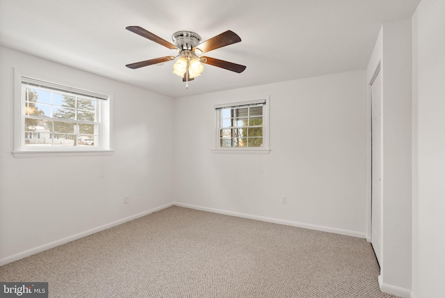 unfurnished room featuring ceiling fan, plenty of natural light, and carpet floors