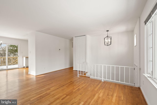 empty room featuring light hardwood / wood-style floors and a chandelier