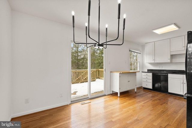 kitchen with a notable chandelier, dishwasher, light hardwood / wood-style floors, and white cabinets