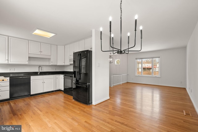 kitchen with white cabinets, sink, light wood-type flooring, and black appliances