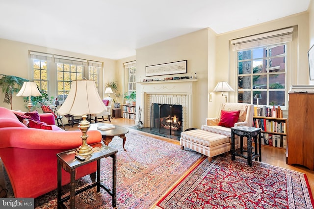 living room with hardwood / wood-style flooring, a wealth of natural light, and a fireplace