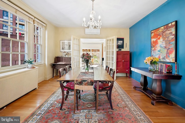 dining room with french doors, radiator, ornamental molding, and light hardwood / wood-style floors