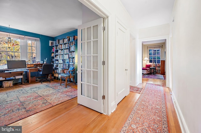 office featuring french doors, a chandelier, and wood-type flooring