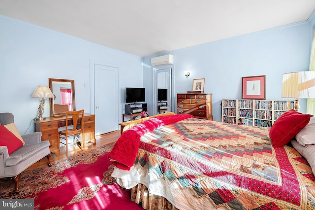 bedroom featuring an AC wall unit and hardwood / wood-style flooring