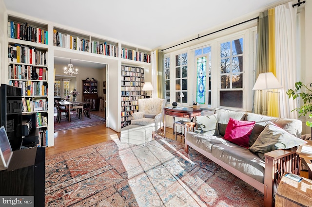 living area with hardwood / wood-style floors and a chandelier