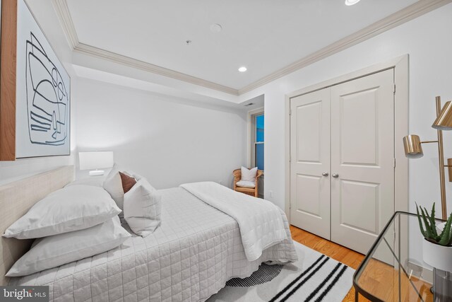 bedroom with light wood-style flooring, recessed lighting, a closet, and ornamental molding