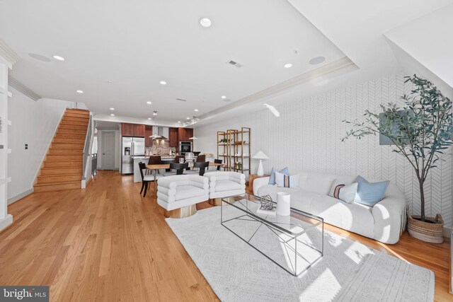 living room with stairs, light wood-style flooring, and recessed lighting