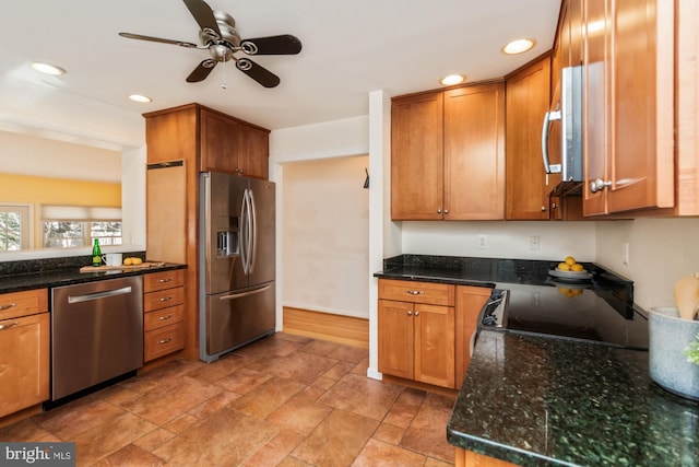 kitchen with ceiling fan, dark stone counters, recessed lighting, brown cabinetry, and stainless steel appliances