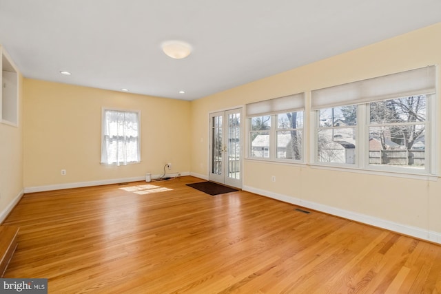 empty room featuring visible vents, baseboards, and light wood-style floors