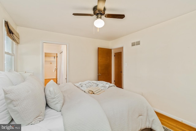 bedroom featuring visible vents, baseboards, light wood-style flooring, and a ceiling fan