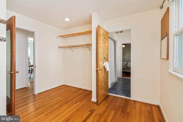 unfurnished bedroom with recessed lighting, a closet, baseboards, and light wood-style floors