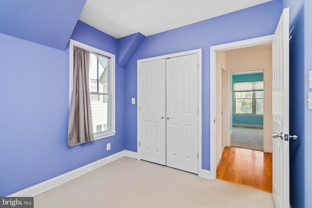 unfurnished bedroom with a closet, baseboards, and carpet