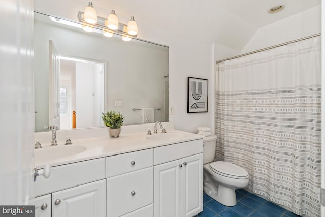 bathroom with tile patterned flooring, double vanity, toilet, and a sink