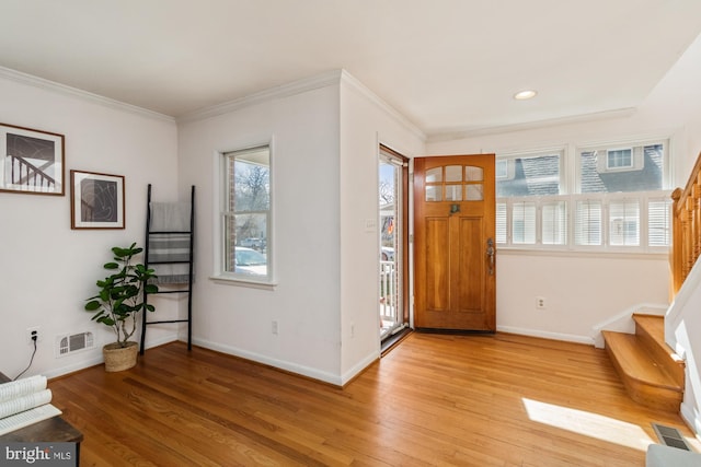 entryway featuring visible vents, baseboards, light wood-style floors, and stairs