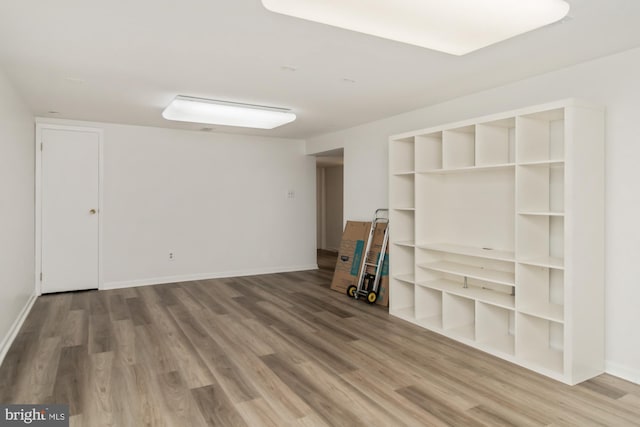 unfurnished living room featuring wood finished floors and baseboards