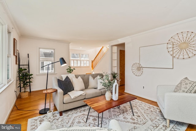 living room with stairs, crown molding, wood finished floors, and baseboards