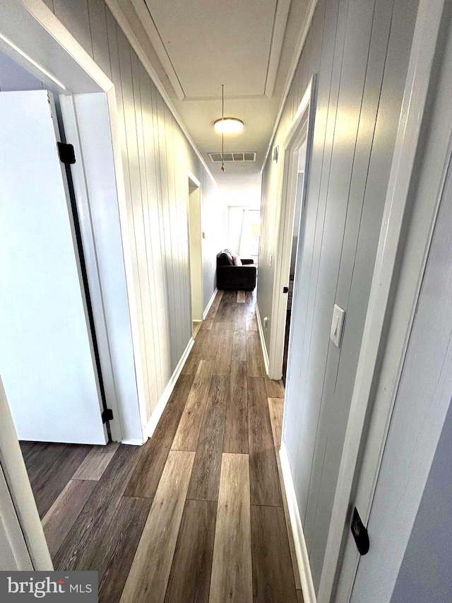 hall with dark hardwood / wood-style flooring and crown molding