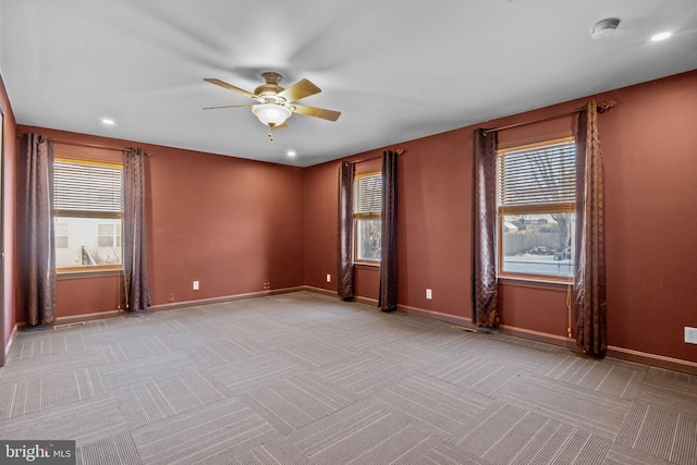 carpeted spare room featuring ceiling fan