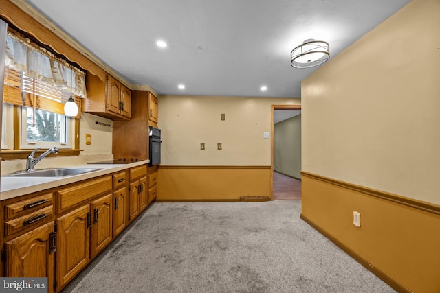 kitchen featuring sink, black appliances, and light carpet