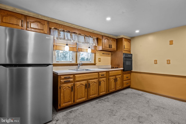 kitchen featuring sink, black appliances, pendant lighting, and light carpet