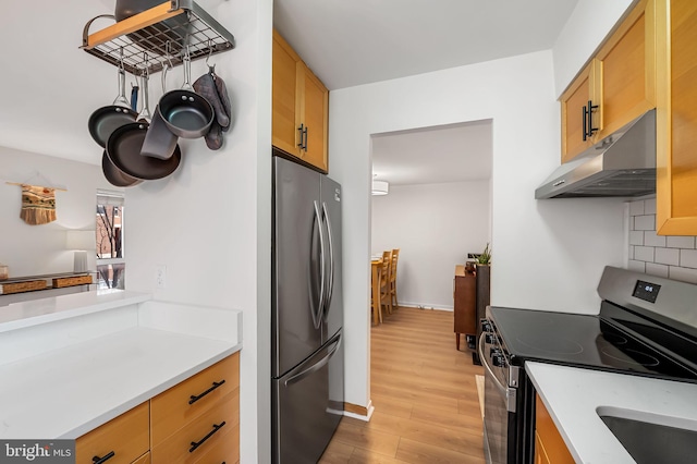 kitchen with backsplash, light hardwood / wood-style flooring, and stainless steel appliances