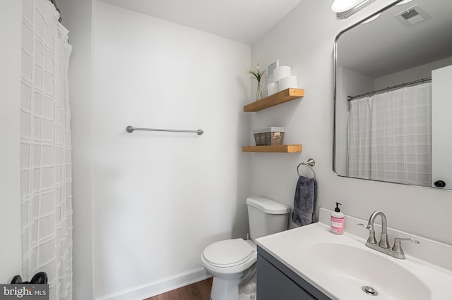 bathroom featuring vanity, hardwood / wood-style flooring, and toilet