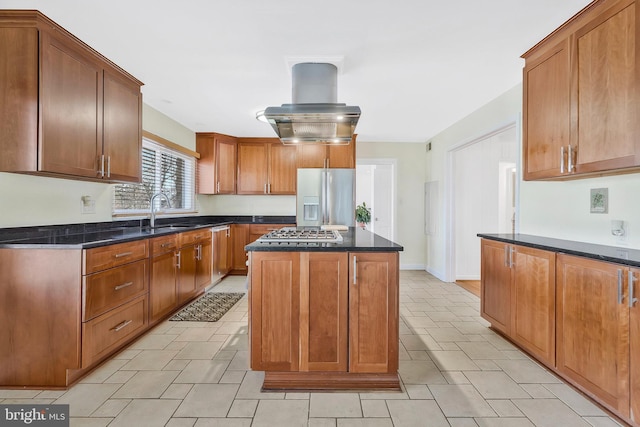 kitchen with sink, appliances with stainless steel finishes, dark stone countertops, a center island, and island range hood