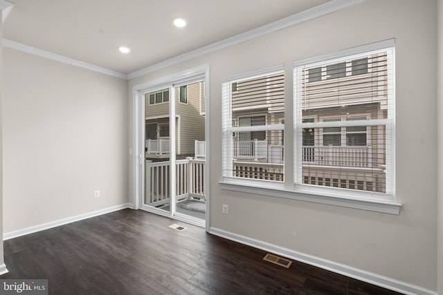 spare room with crown molding and dark wood-type flooring