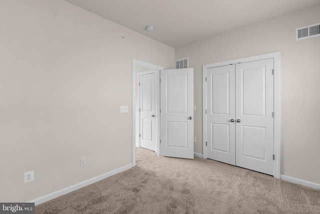 unfurnished bedroom featuring a closet and light carpet