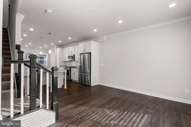 kitchen featuring stainless steel appliances, white cabinetry, a center island, and a kitchen bar