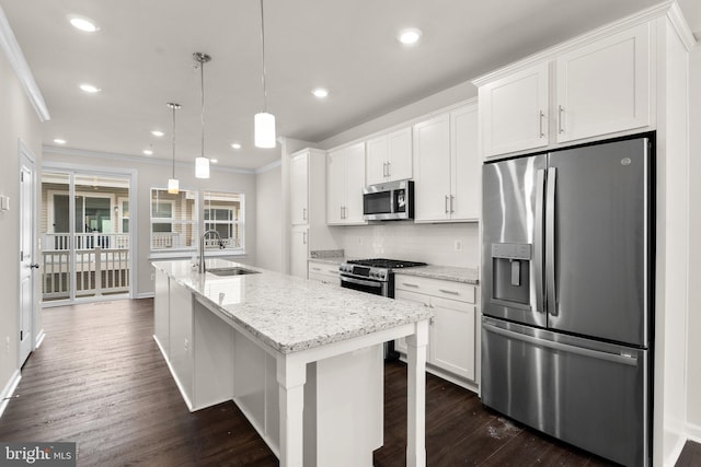 kitchen featuring pendant lighting, an island with sink, sink, white cabinets, and stainless steel appliances