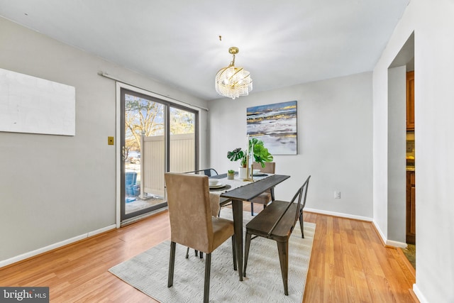 dining space featuring an inviting chandelier and light hardwood / wood-style flooring