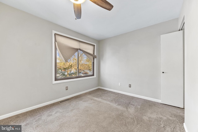 carpeted spare room featuring ceiling fan