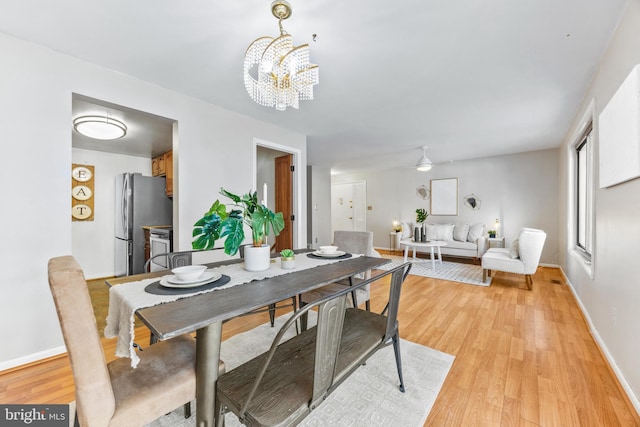 dining space featuring light hardwood / wood-style flooring and a chandelier